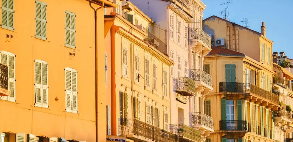 Façades ocre et volets pastel d'une ruelle de la vieille ville de Nice